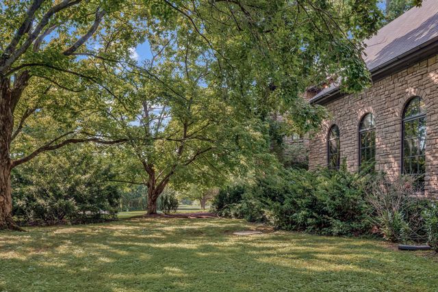 a living room with furniture fireplace and large windows