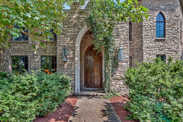 a living room with furniture a fireplace and a floor to ceiling window