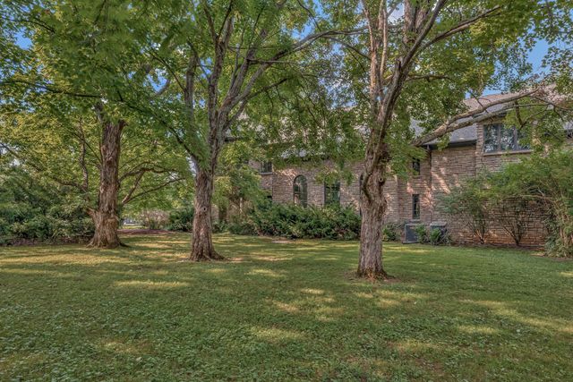 a living room with furniture a fireplace and large windows