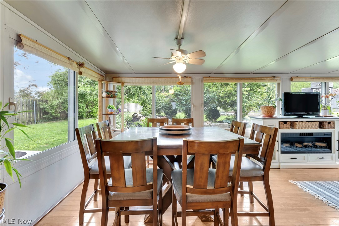8704 Columbia Road Olmsted Falls, OH 44138 - Photo 6 of 34 Dining area featuring expansive windows, wood-finish flooring, and a ceiling fan with integrated lighting