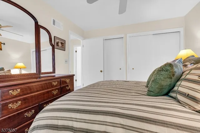 a bedroom with a bed and a dresser with mirror