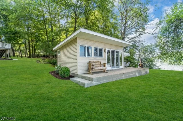 a view of a lake with a big yard and large trees