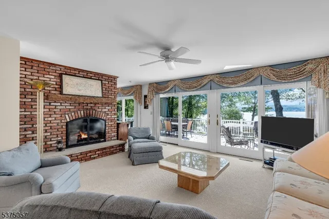 a living room with furniture a fireplace and a large window with balcony view