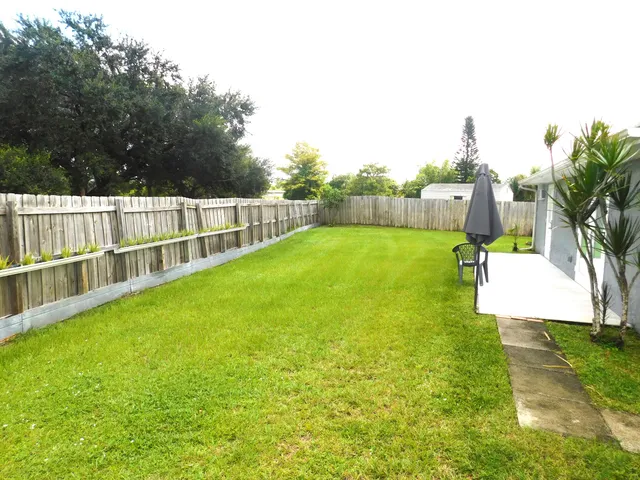 a view of a deck with a big yard and potted plants