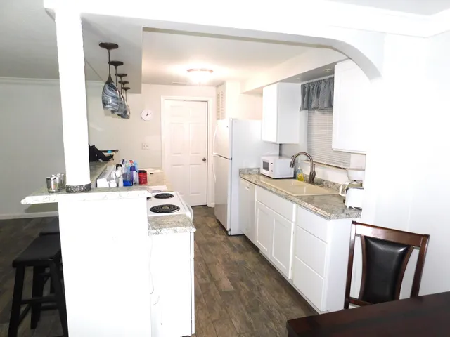 a kitchen with a sink stove and white cabinets