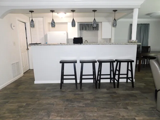 a kitchen with granite countertop a table chairs stove and cabinets