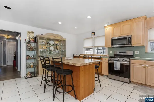 a kitchen with stainless steel appliances granite countertop a stove top oven a sink dishwasher and a refrigerator with cabinets