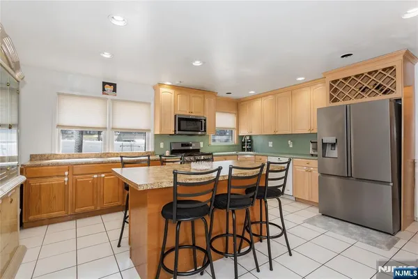 a kitchen with stainless steel appliances kitchen island granite countertop a refrigerator and microwave