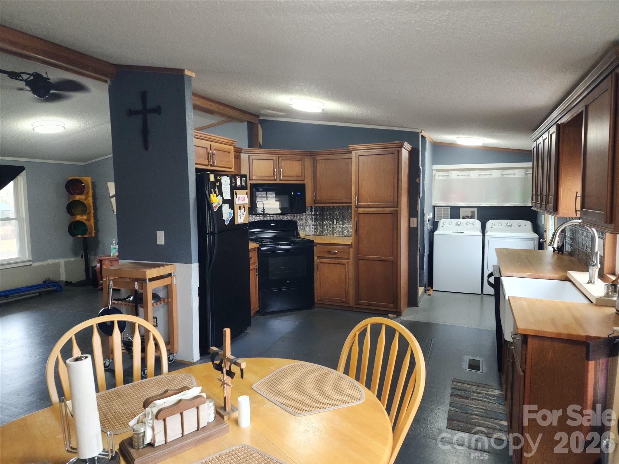 303 Johnson Dairy Road Mooresville, NC 28115 - Photo 16 of 36 a kitchen with sink refrigerator dining table and chairs