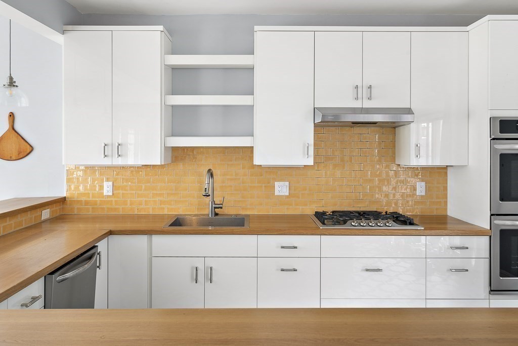 10 Spring Hill Terrace Somerville, MA 02143 - Photo 3 of 20 a kitchen with granite countertop white cabinets and white appliances