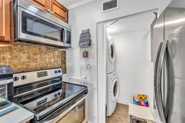 a kitchen with stainless steel appliances granite countertop a refrigerator and a stove top oven