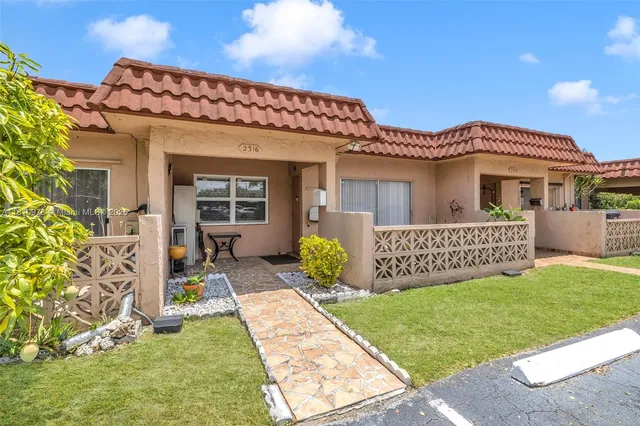 a view of a house with a yard and porch
