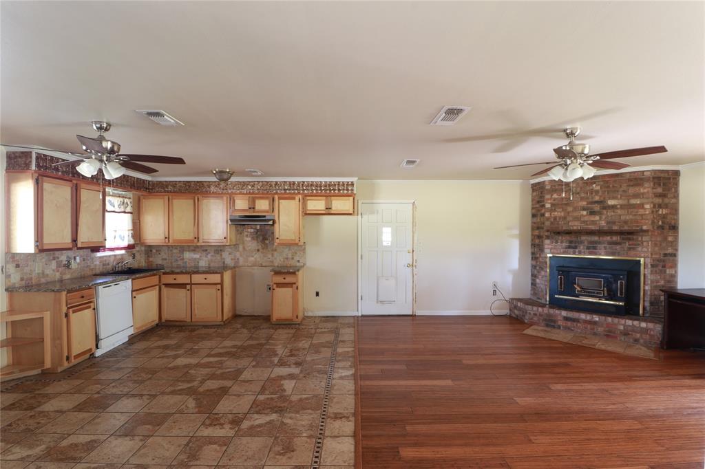 212 Palmer Drive Comanche, TX 76442 - Photo 11 of 40 a large white kitchen with a sink and dishwasher a stove top oven with wooden floor