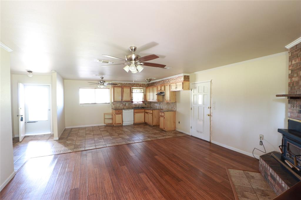 212 Palmer Drive Comanche, TX 76442 - Photo 10 of 40 a view of a livingroom with wooden floor and a ceiling fan