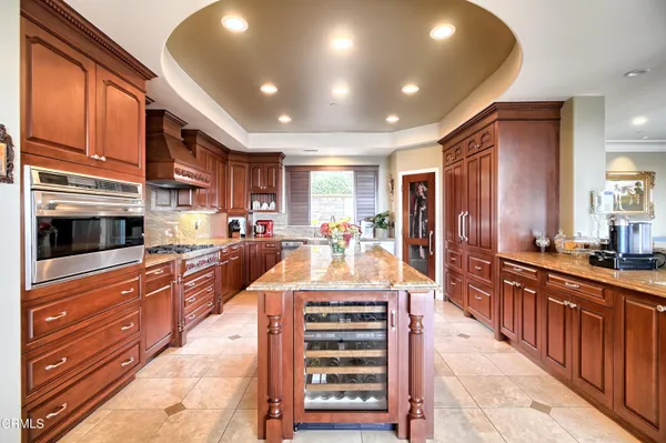 a kitchen with kitchen island granite countertop a stove and cabinets