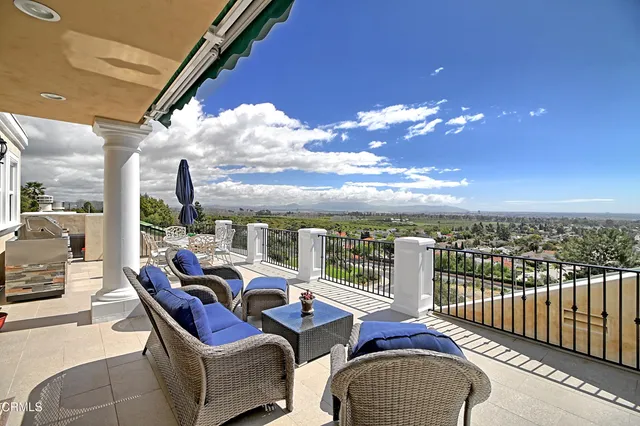 a view of a brick house with many windows and a tree