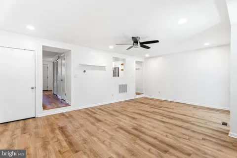 a view of a livingroom with wooden floor and a ceiling fan