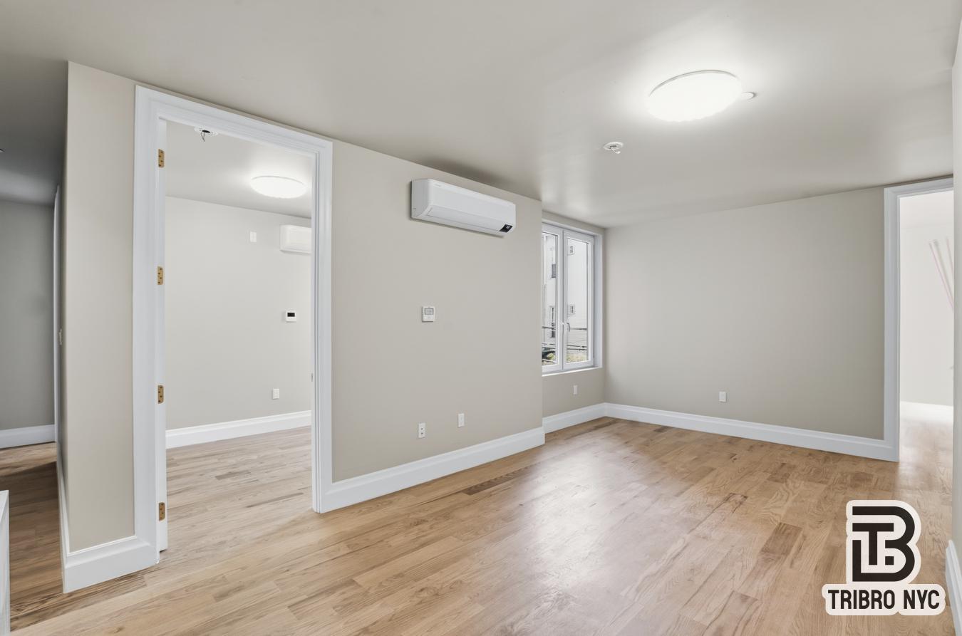 129 Russell Street, Unit 1D Brooklyn, NY 11222 - Photo 12 of 13 wooden floor in an empty room with a window