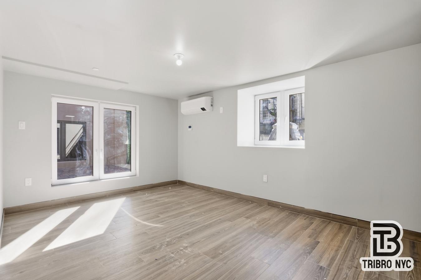 129 Russell Street, Unit 1D Brooklyn, NY 11222 - Photo 5 of 13 a view of an empty room with a window and wooden floor
