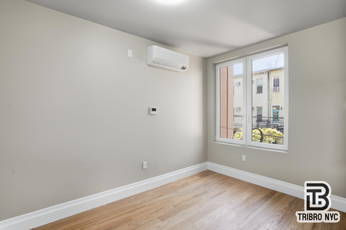 129 Russell Street, Unit 1D Brooklyn, NY 11222 - Photo 9 of 13 a view of an empty room with wooden floor and a window