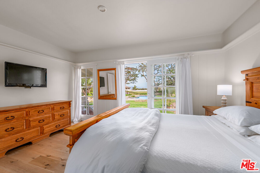 7016 Dume Drive Malibu, CA 90265 - Photo 20 of 24 a bedroom with a large bed and a flat tv screen on dresser