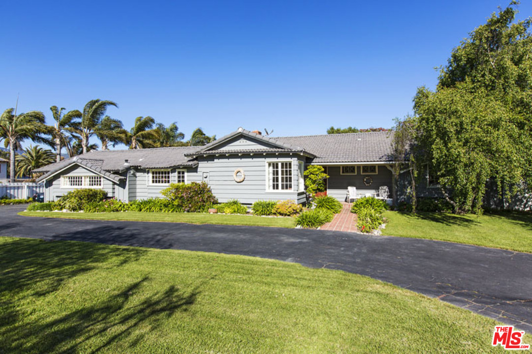 7016 Dume Drive Malibu, CA 90265 - Photo 2 of 24 a front view of a house with a yard and garage