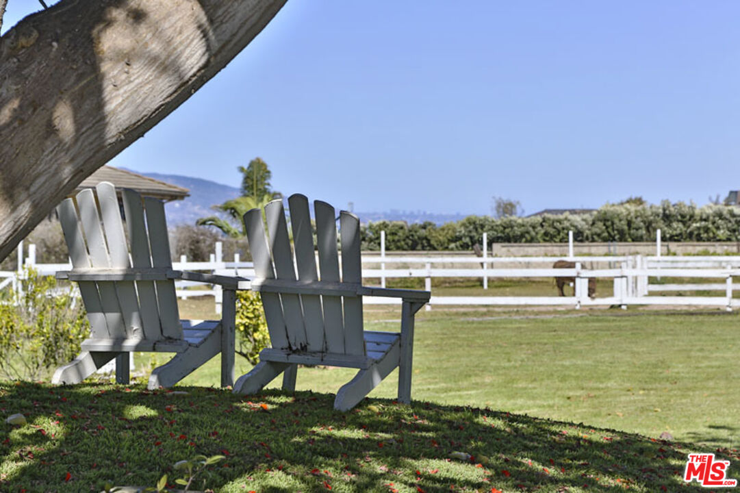 7016 Dume Drive Malibu, CA 90265 - Photo 24 of 24 a view of a swimming pool with an outdoor seating and a yard