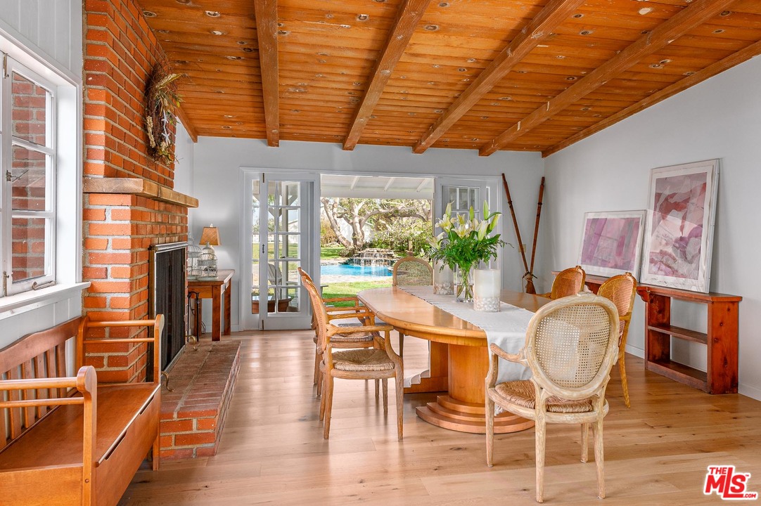 7016 Dume Drive Malibu, CA 90265 - Photo 6 of 24 a dining room with wooden floor and large windows