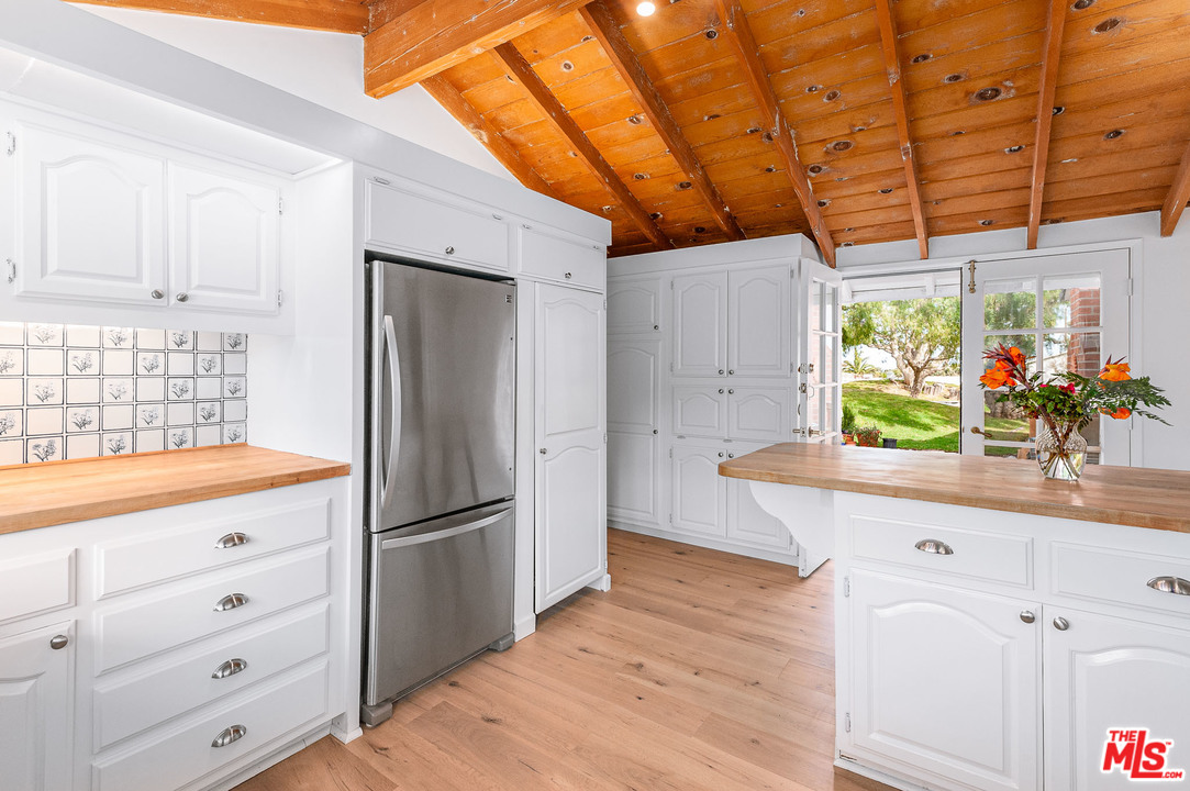 7016 Dume Drive Malibu, CA 90265 - Photo 9 of 24 a kitchen with stainless steel appliances kitchen island granite countertop a refrigerator and a sink