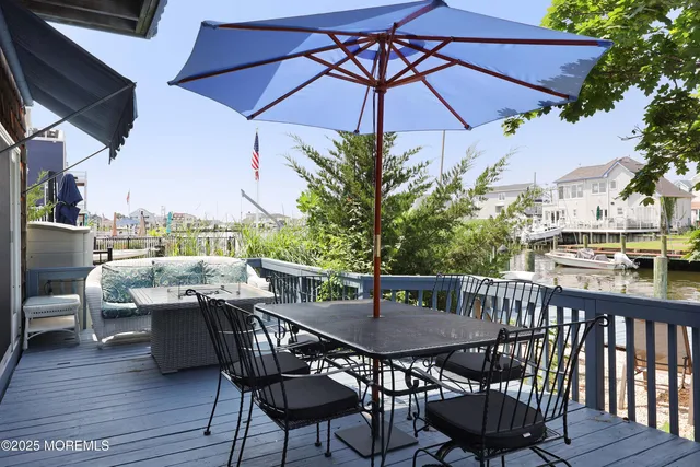 a view of a roof deck with table and chairs under an umbrella