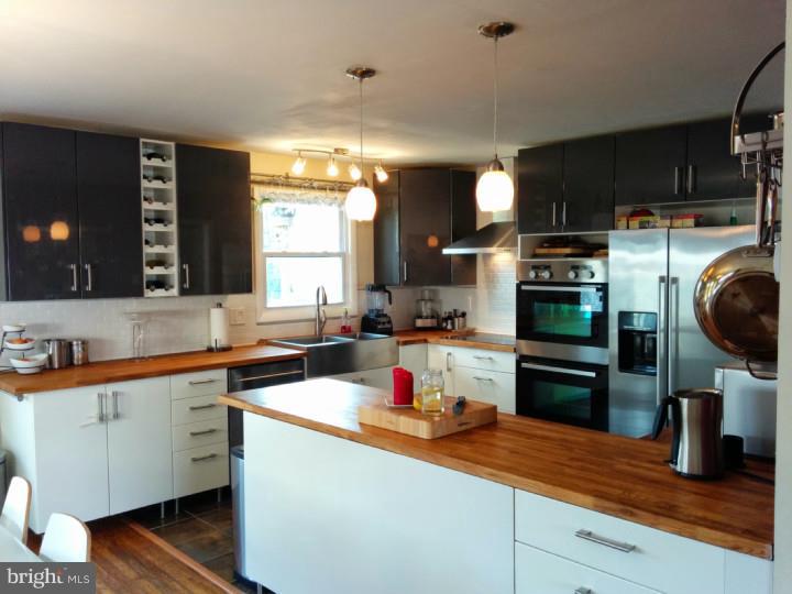 1241 Dill Road Havertown, PA 19083 - Photo 5 of 14 a kitchen with a sink dishwasher stove and wooden cabinets
