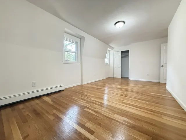 a view of empty room with wooden floor