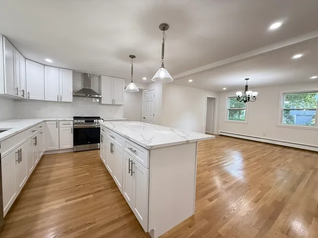 a large kitchen with a white stove top oven and cabinets