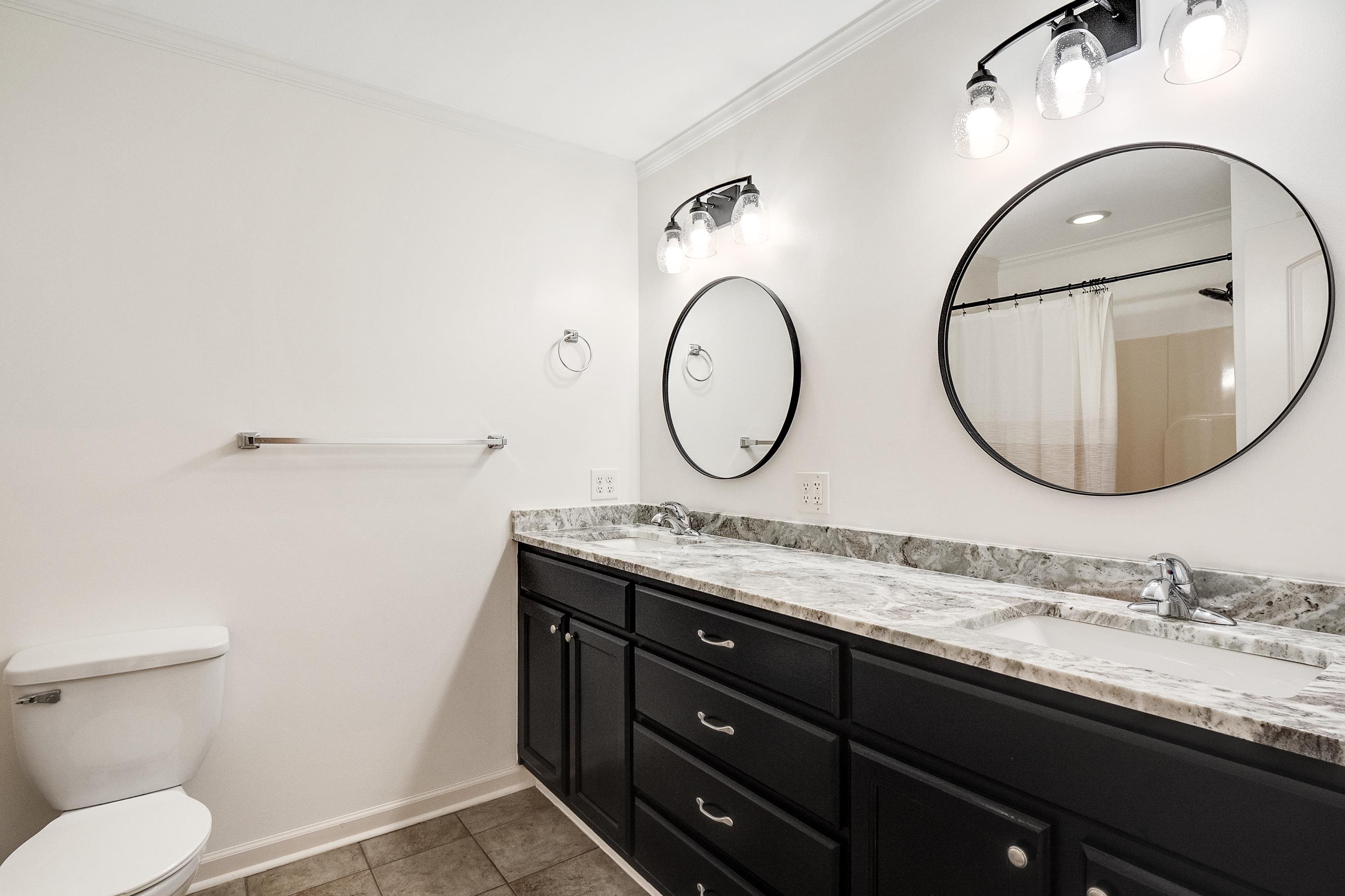4412 Helene Road Memphis, TN 38117 - Photo 15 of 19 a bathroom with a granite countertop toilet a sink and a mirror
