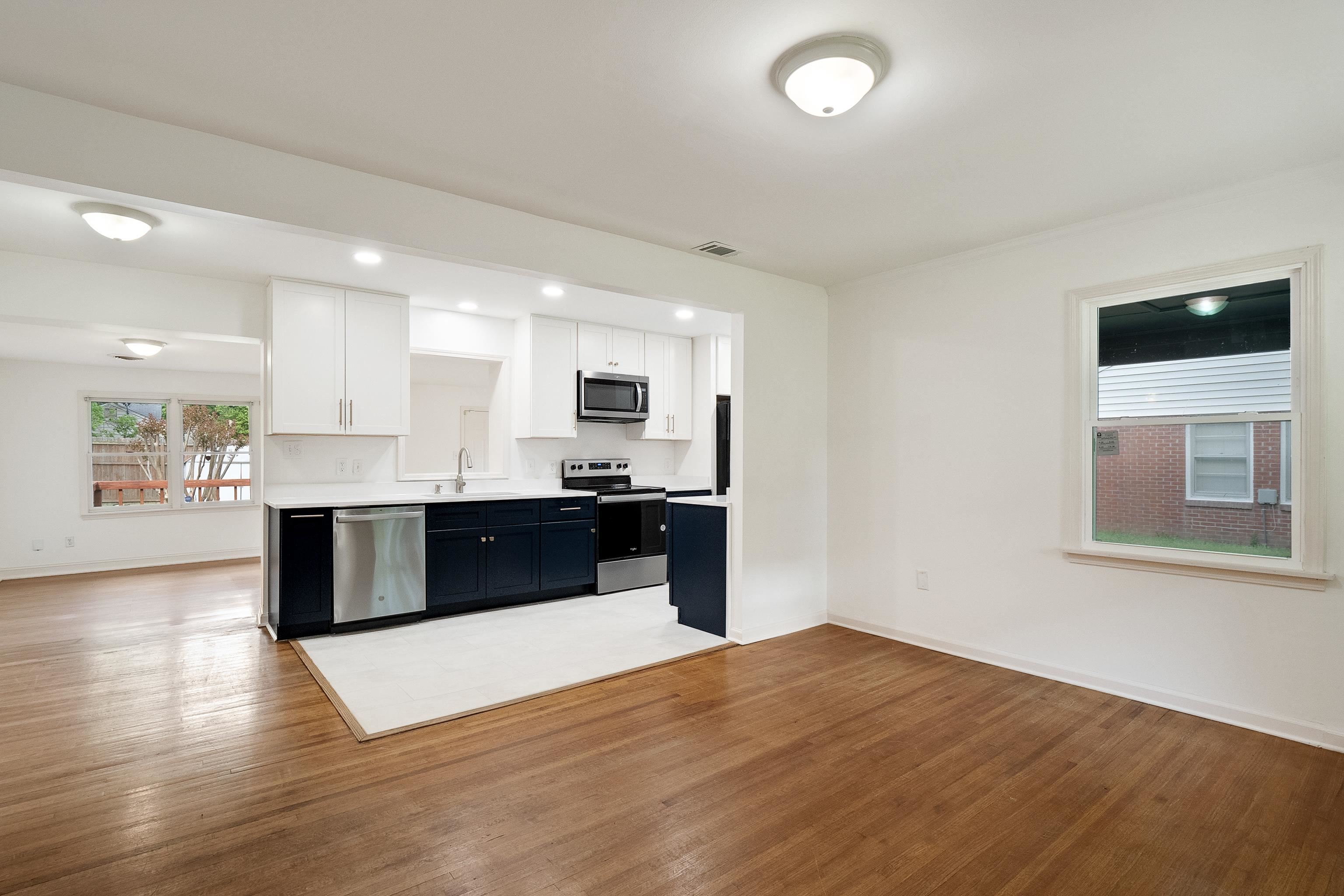 4412 Helene Road Memphis, TN 38117 - Photo 2 of 19 a large white kitchen with kitchen island a sink dishwasher a stove and a refrigerator with wooden floor