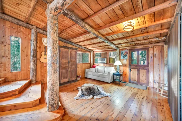 a living room with furniture a flat screen tv and a floor to ceiling window
