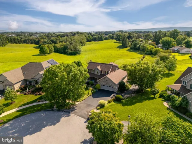 an aerial view of a house with a yard and outdoor seating