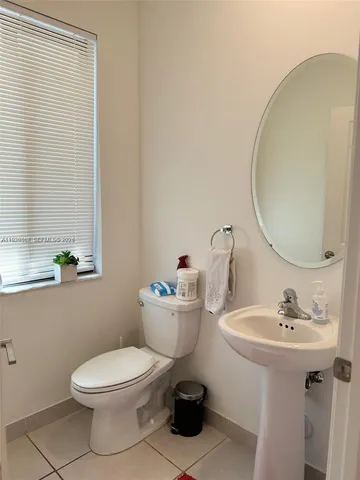 a bathroom with a sink mirror and toilet