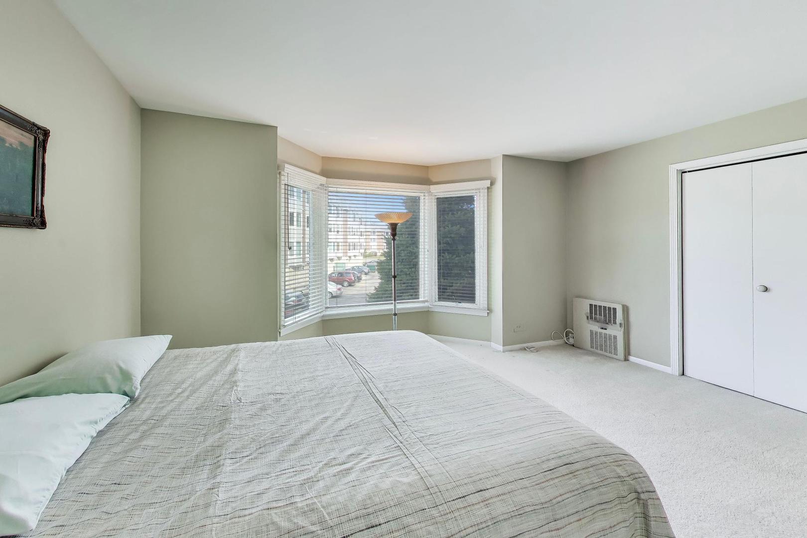400 Ascot Drive, Unit 1M Park Ridge, IL 60068 - Photo 24 of 37 a bedroom with a large bed and a window