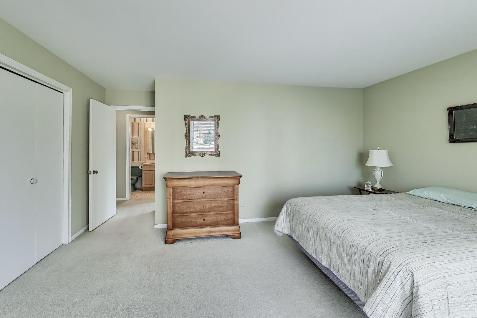 400 Ascot Drive, Unit 1M Park Ridge, IL 60068 - Photo 25 of 37 a bedroom with a bed and a flat screen tv