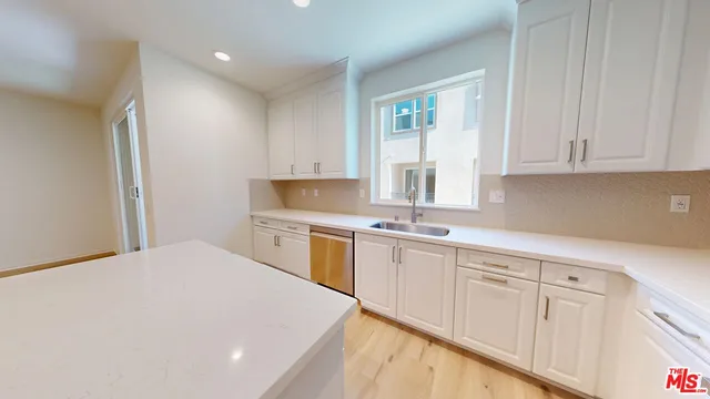 a kitchen with white cabinets and white appliances