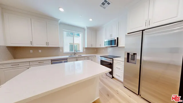 a kitchen with granite countertop a refrigerator and a sink