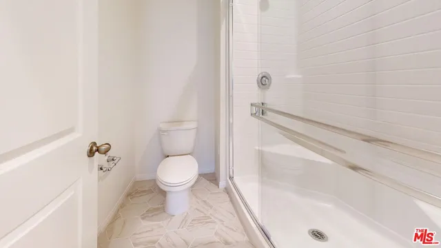 a bathroom with a toilet and a shower