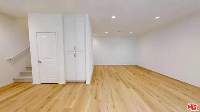 a view of empty room with wooden floor and entryway