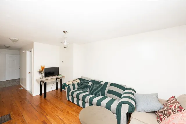 a living room with furniture flat screen tv and kitchen view