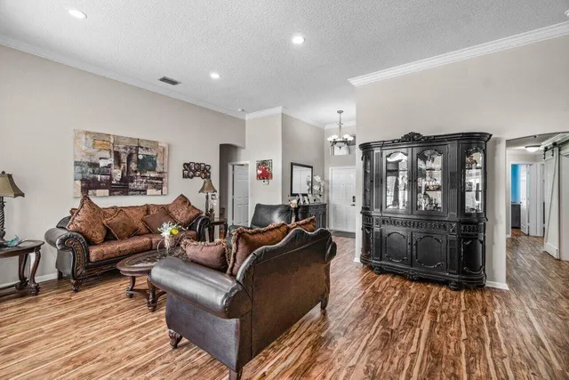 a open kitchen with stainless steel appliances granite countertop a stove top oven a sink dishwasher a dining table and chairs with wooden floor