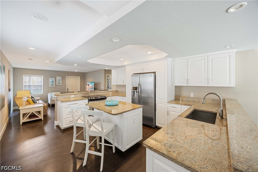 856 104th Avenue North Naples, FL 34108 - Photo 8 of 35 a kitchen with stainless steel appliances granite countertop a table chairs and wooden floor