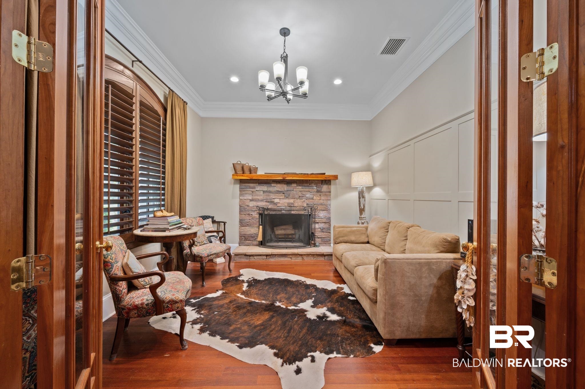 7850 Yorkhaven Road Mobile, AL 36695 - Photo 9 of 57 Living room with visible vents, crown molding, a fireplace, an inviting chandelier, and wood finished floors