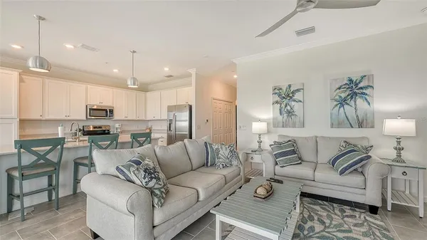 a kitchen with stainless steel appliances granite countertop a stove a sink dishwasher a dining table and chairs with white cabinets