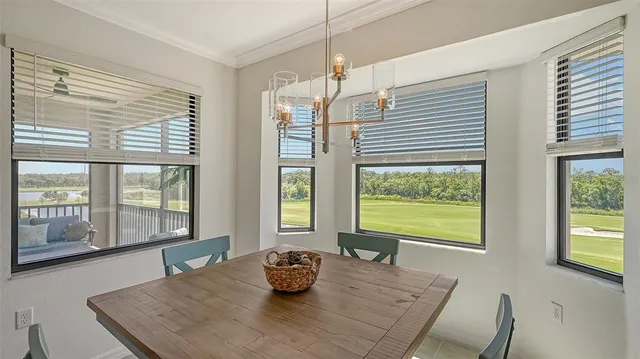 a dining hall with stainless steel appliances kitchen island granite countertop a table chairs and a view of living room